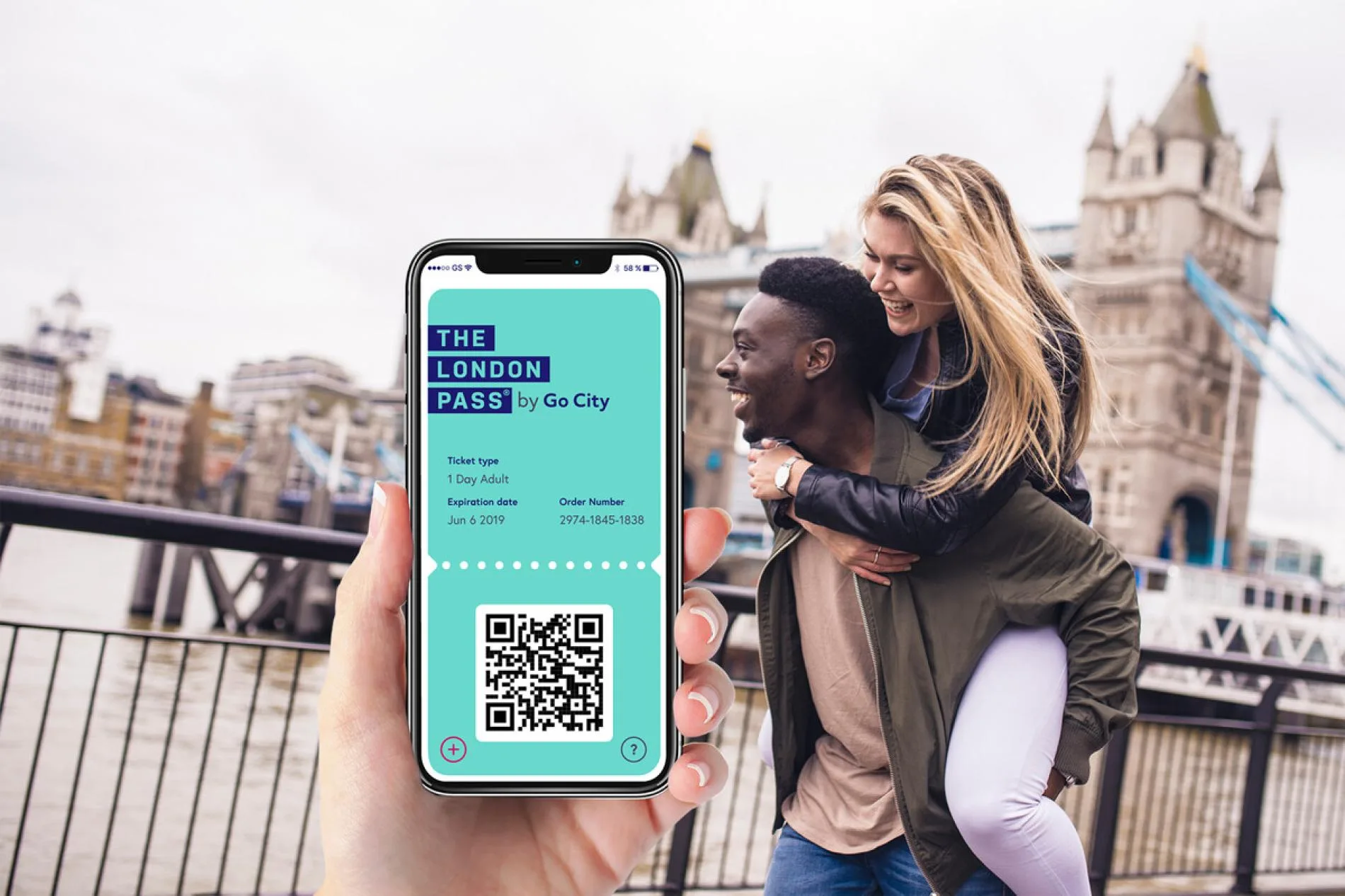 Le London Pass affiché sur un téléphone, devant Tower Bridge